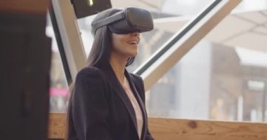 Gelecekteki VR Eğitim Teknolojisi güzel çok ırklı kadın bir restoranın menüsünü kaydırmak için sanal gerçeklik kulaklığı kullanıyor. Kadın randevu almak için Artırılmış Gerçeklik VR gözlüğü kullanıyor. 4k 