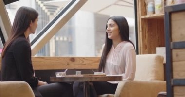 Elektronik ödeme makinesi ya da kart okuyucu üzerinden kredi kartıyla öde. Nakitsiz cüzdanda E-para. Kadın müşteri öğle yemeğinden sonra arkadaşıyla birlikte kahve dükkanında ya da restoranda çalışanın pospostal terminaline el koyuyor..