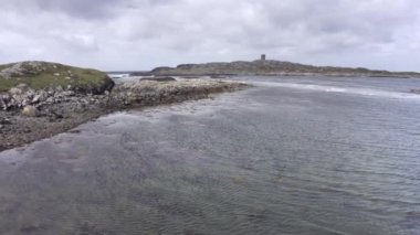 Aerial view of low tide seascape. Beautiful Drone point of view fly of irish coast line at low tide, in the background lighthouse, calm sea in a cloudy day. High quality 4k footage