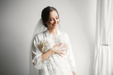 Tüylü, lüks makyaj, saç stili, stüdyo içi fotoğraf çekimi olan güzel bir gelin.