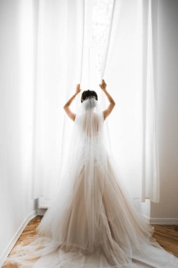 Beyaz elbiseli lüks gelin düğün törenine hazırlanırken poz veriyor.