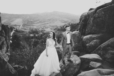 Harika bir gelin damada poz veriyor ve harika manzaralı dağlarda eğleniyor. Mesajlaşacak yer, düğün çifti.