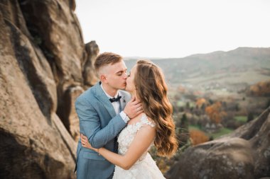 Harika bir gelin damada poz veriyor ve harika manzaralı dağlarda eğleniyor. Mesajlaşacak yer, düğün çifti.