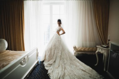 Beyaz elbiseli lüks gelin düğün törenine hazırlanırken poz veriyor.