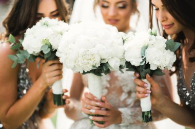 Gelin ve nedimeler düğün günü farklı çiçeklerden harika bir lüks düğün buketi tutuyor.