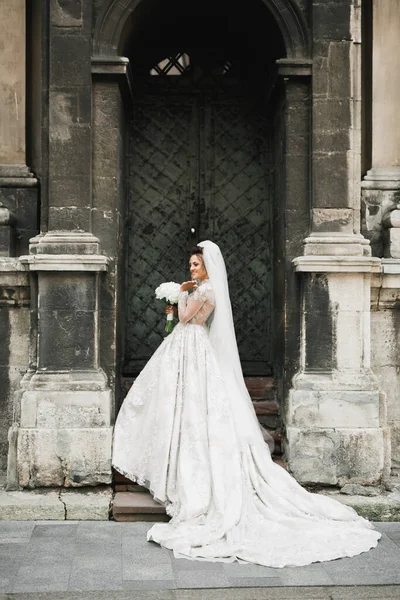 Gelin çiçekli büyük ve güzel bir düğün buketi tutuyor.