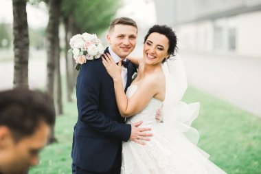 Parkta kucaklaşan yeni evli çiftin güzel romantik düğünü.