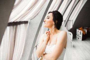 Tüylü, lüks makyaj, saç stili, stüdyo içi fotoğraf çekimi olan güzel bir gelin.