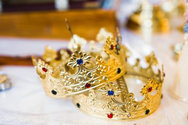 Kilisedeki masanın üzerinde altın taçlar var.