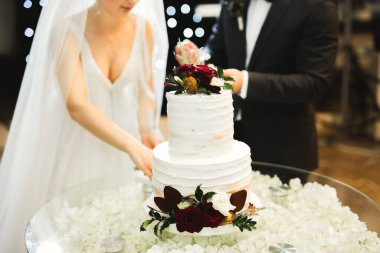 Gelin ve damat düğün pastasını kesiyor.