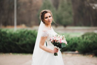 Gelin çiçekli büyük ve güzel bir düğün buketi tutuyor.