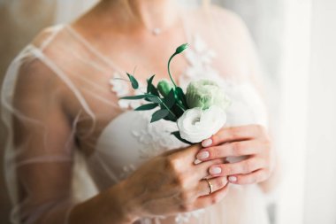 Çekici gelinin portresi, uzun saçlı, büyük buketli poz veren.