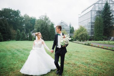 Botanik parkında yürüyen mutlu bir çift.