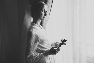 Lüks bir gelin, bir kız buketle poz veriyor ve gülümsüyor.