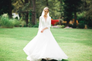 Gelinlik içinde dışarıda poz veren güzel gelin.