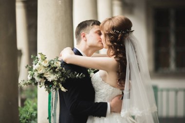 Güzel, mutlu bir düğün çifti, güzel şehirde uzun beyaz elbiseli bir gelin.