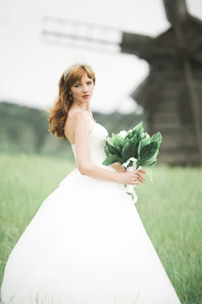 Портрет потрясающей невесты с длинными волосами, позирующей с большим букетом — стоковое фото