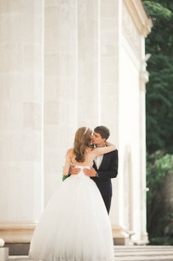 Güzel, mutlu bir düğün çifti, güzel şehirde uzun beyaz elbiseli bir gelin.