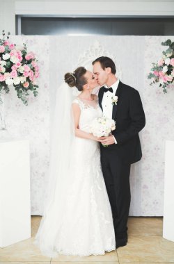 Mükemmel bir çift gelin ve damat düğün günlerinde poz verip öpüşürler.