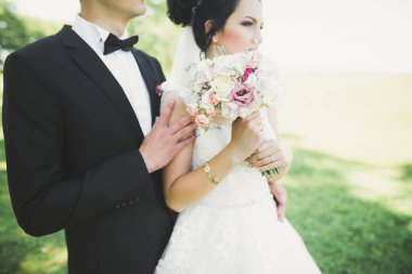 Yeni evli çift el ele tutuşurken parkta koşup zıplıyorlar.