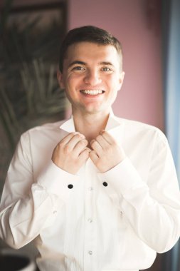 Güzel adam, damat poz veriyor ve düğüne hazırlanıyor.