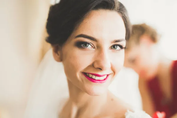 Preciosa novia en bata posando y preparándose para la ceremonia de boda cara en una habitación — Foto de Stock