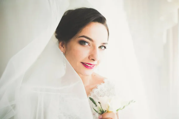 Nádherná nevěsta v županu pózuje a připravuje se na svatební obřad tvář v místnosti — Stock fotografie