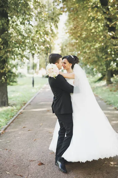 Lyckligt bröllop par charmiga brudgummen och perfekt brud poserar i park — Stockfoto
