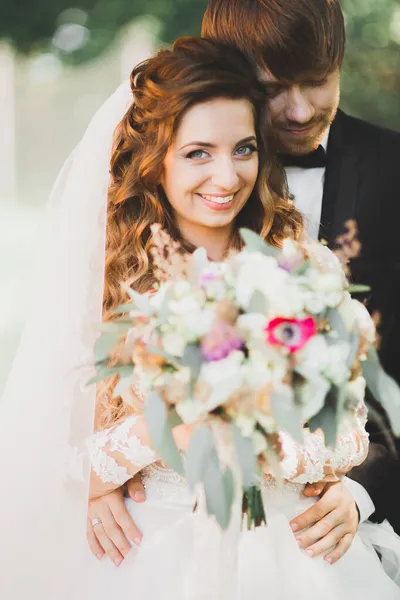 Güzel romantik bir çift yeni evliler gün batımında parkta sarılıyorlar. — Stok fotoğraf