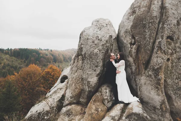 Joyeux couple de mariage posant sur un beau paysage dans les montagnes — Photo