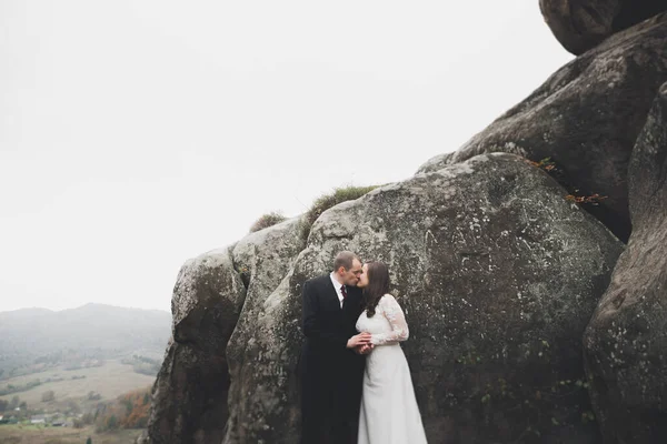Joyeux couple de mariage posant sur un beau paysage dans les montagnes — Photo