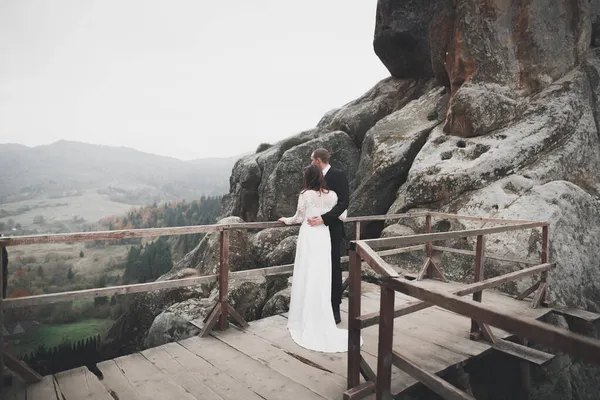 Casal feliz posando sobre bela paisagem nas montanhas — Fotografia de Stock