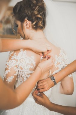 Beyaz elbiseli lüks gelin düğün törenine hazırlanırken poz veriyor.