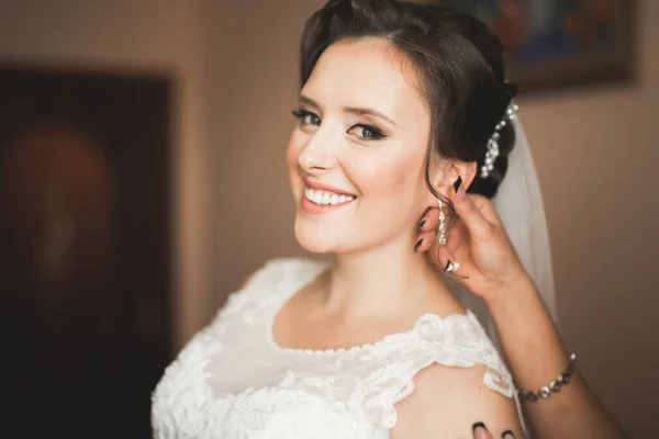 Novia de lujo en vestido blanco posando mientras se prepara para la ceremonia de boda — Foto de Stock