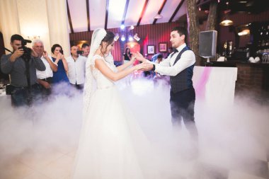 Güzel beyaz bir çift yeni evlendiler ve ilk danslarını ediyorlar.
