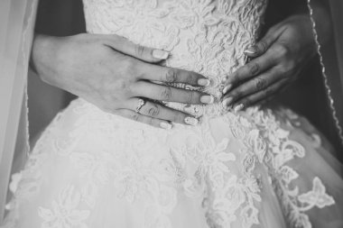 Cüppeli muhteşem gelin bir odada düğün töreni için poz veriyor ve hazırlanıyor.