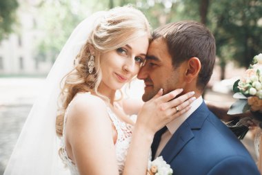 Güzel, mutlu bir düğün çifti, güzel şehirde uzun beyaz elbiseli bir gelin.