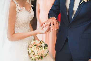 Gelin ve damat alyanslarını değiş tokuş ediyorlar. Şık bir çift töreni.