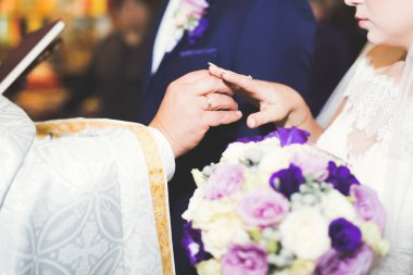 Gelin ve damat alyanslarını değiş tokuş ediyorlar. Şık bir çift töreni.