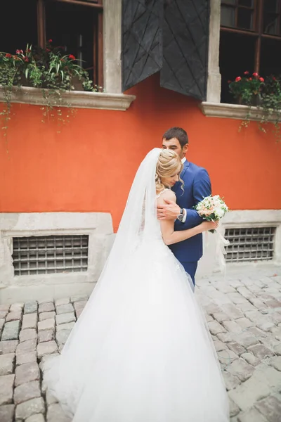 素敵な幸せな結婚式のカップル、美しい街でポーズをとる長い白いドレスの花嫁 — ストック写真