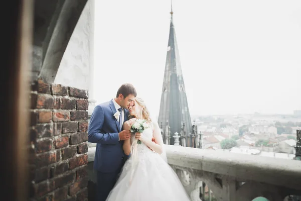 Elegante hermosa pareja de boda besándose y abrazándose en el fondo vista panorámica del casco antiguo — Foto de Stock