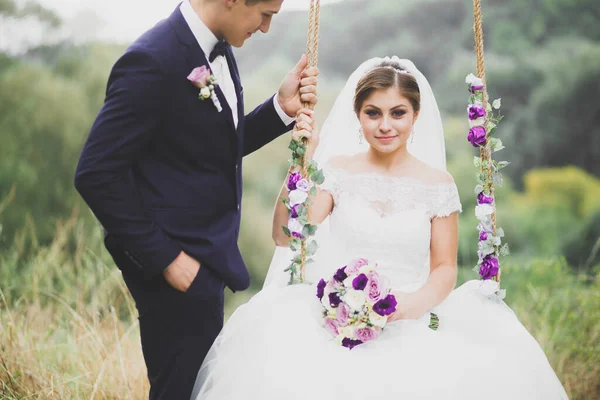 Perfektes Paar Braut, Bräutigam posiert und küsst sich am Hochzeitstag — Stockfoto