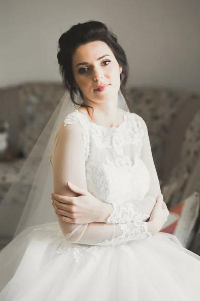 Novia de lujo en vestido blanco posando mientras se prepara para la ceremonia de boda — Foto de Stock