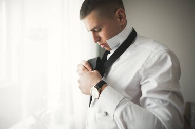 Güzel adam, damat poz veriyor ve düğüne hazırlanıyor.