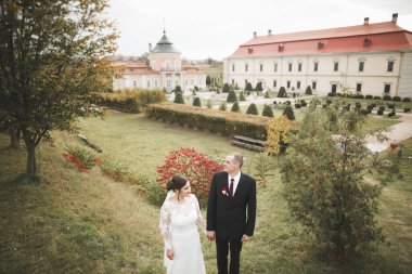 İnanılmaz mutlu nazik stil güzel romantik beyaz çift arka planda antik barok kalesinde.