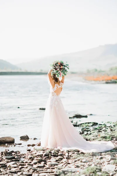 Krásná Brunetka Nevěsta Elegantních Bílých Šatech Držení Kytice Pózuje Blízkosti — Stock fotografie