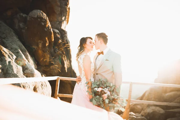 年轻夫妇 新婚夫妇 新郎新娘亲吻 拥抱在完美的山景 蔚蓝的天空 — 图库照片
