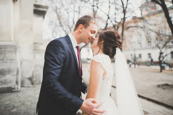 結婚式の日には花束を持って公園を歩く幸せなスタイリッシュな新婚夫婦 — ストック写真