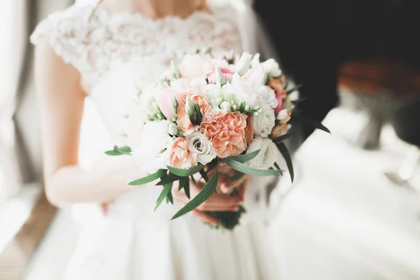 新娘手里拿着花束 又大又漂亮的婚纱 — 图库照片