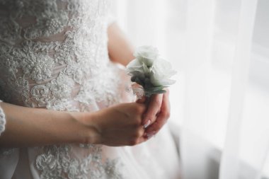 Cüppeli muhteşem gelin bir odada düğün töreni için poz veriyor ve hazırlanıyor..